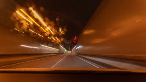 driving fast as timelapse of a tunnel underground drive with a car by looking through its windshield at a rainy night