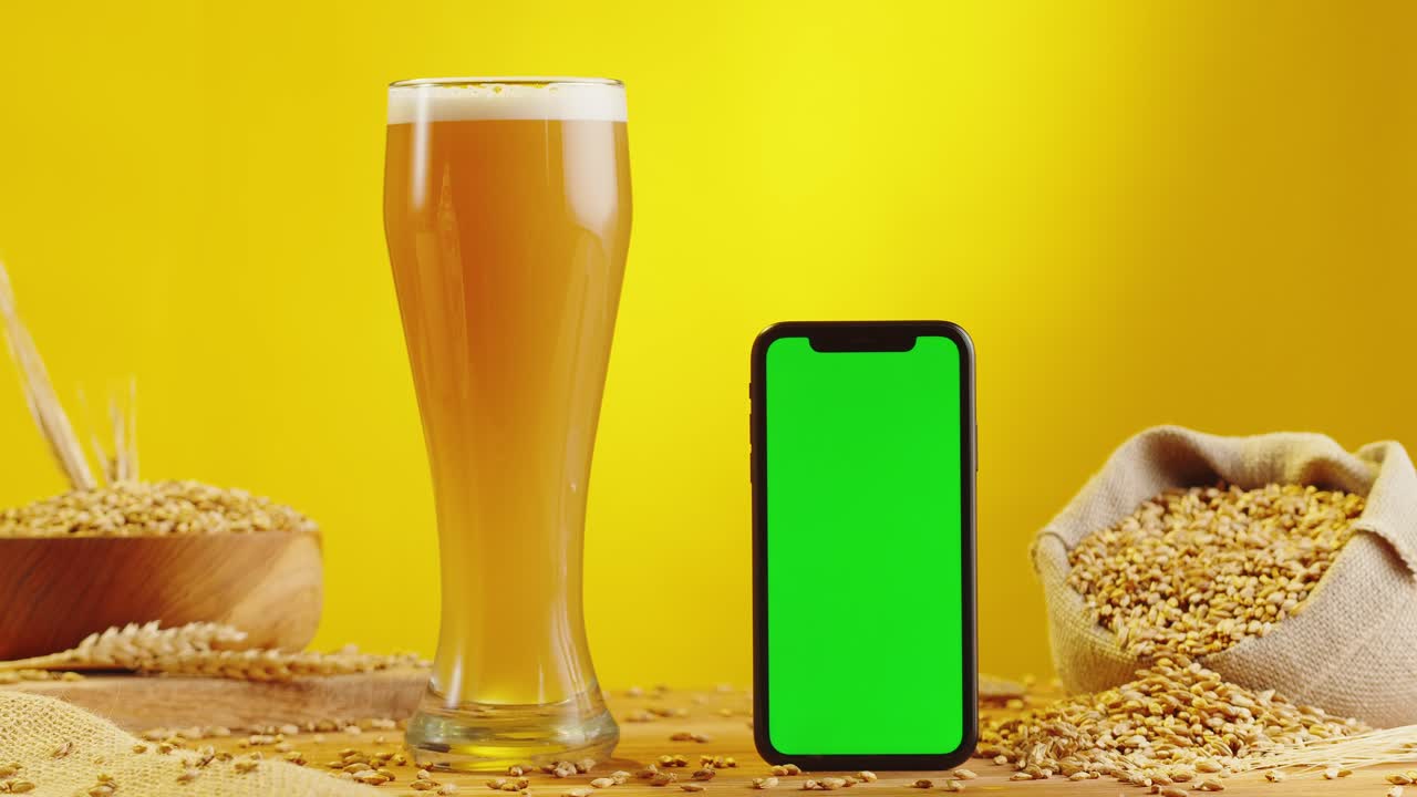 Beer and Smartphone on Wooden Table with Barley