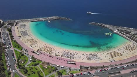 flight over of the sunny amadores beach (playa de amadores) and turquoise sea, gran canaria, canary islands, spain