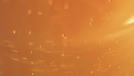 extreme close up of beer bubbles rising in a curved pint glass, copy space background