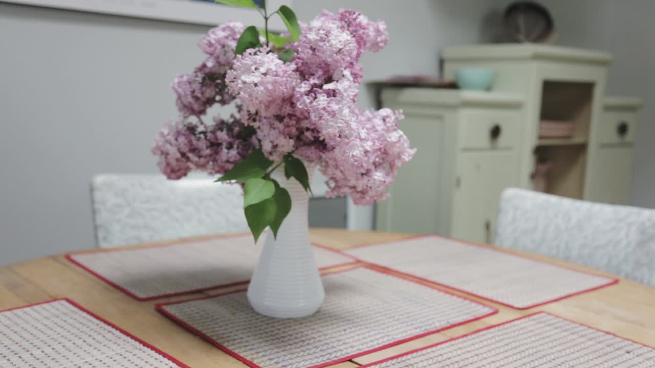 toma panorámica de un ramo de lilas en una mesa de cocina