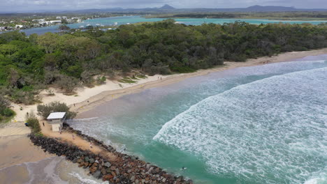 Toma-Aérea-Sobre-El-Extremo-Despoblado-De-La-Playa-De-Noosa-Con-Caminantes-Y-Olas-Rodando