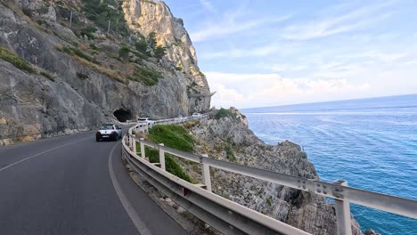 cars driving along a cliffside coastal road