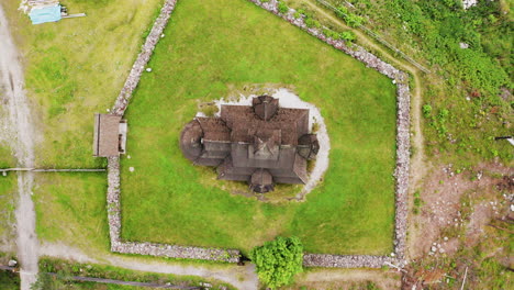 Top-View-Of-Gol-Stave-Church-In-Oslo,-Norway-Situated-On-A-Green-Grassy-Field---descending-drone-shot