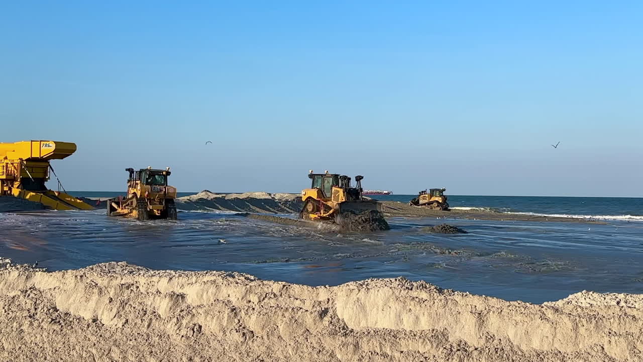 Construction equipment actively working on beach sand replenishment