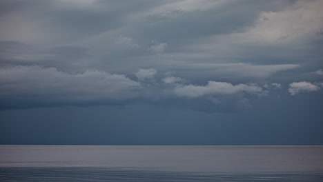 at dusk, an ominous cloud cover forms above the water, predicting a storm