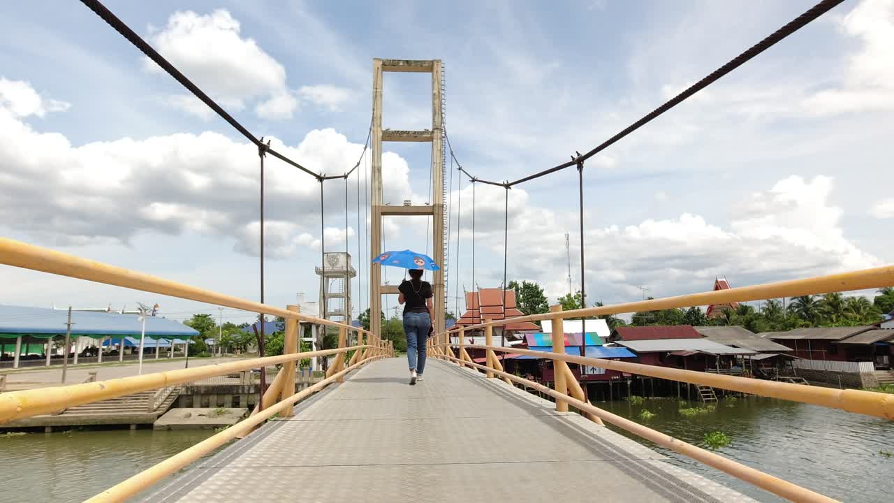 dama asiática cruzando un puente peatonal