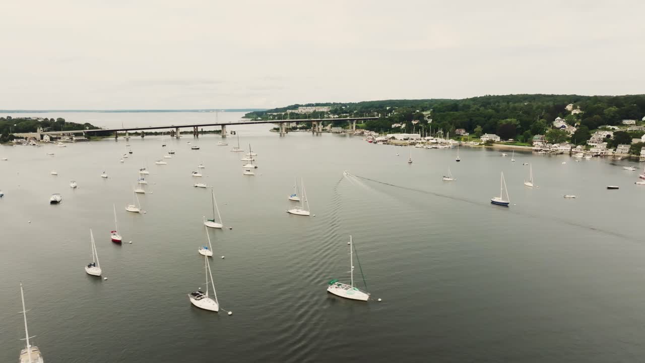 Aerial expansive view of coastal town with sail boats and vessels over bay water in Rhode Island