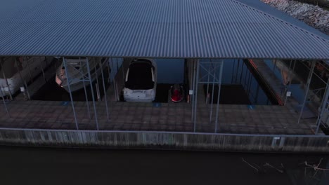 Aerial-drone-footage-in-front-of-boat-dock-panning-to-the-left-at-sunset-with-calm-water