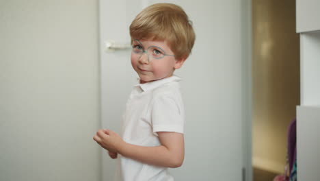 preschooler with painted glasses has fun dancing in room