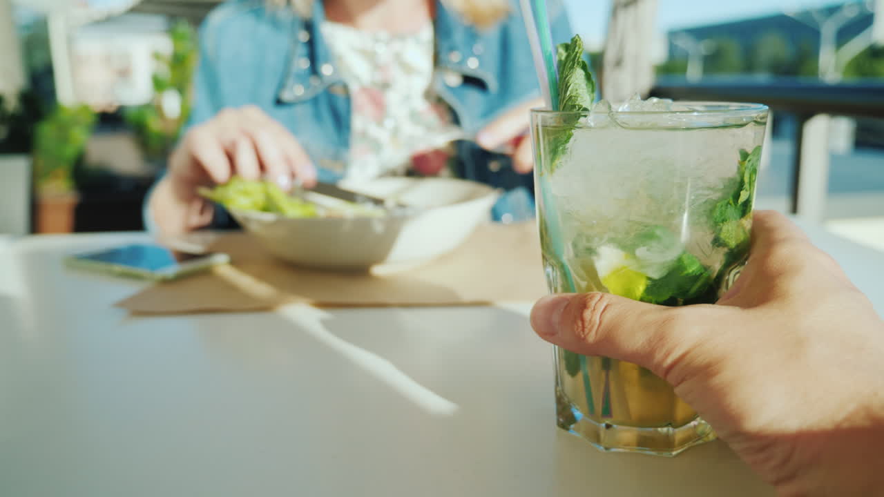 한 커플이 카페에서 쉬고 있다 1인칭 시점 - 칵테일 잔을 들고 있는 남자 t에 있는 여자