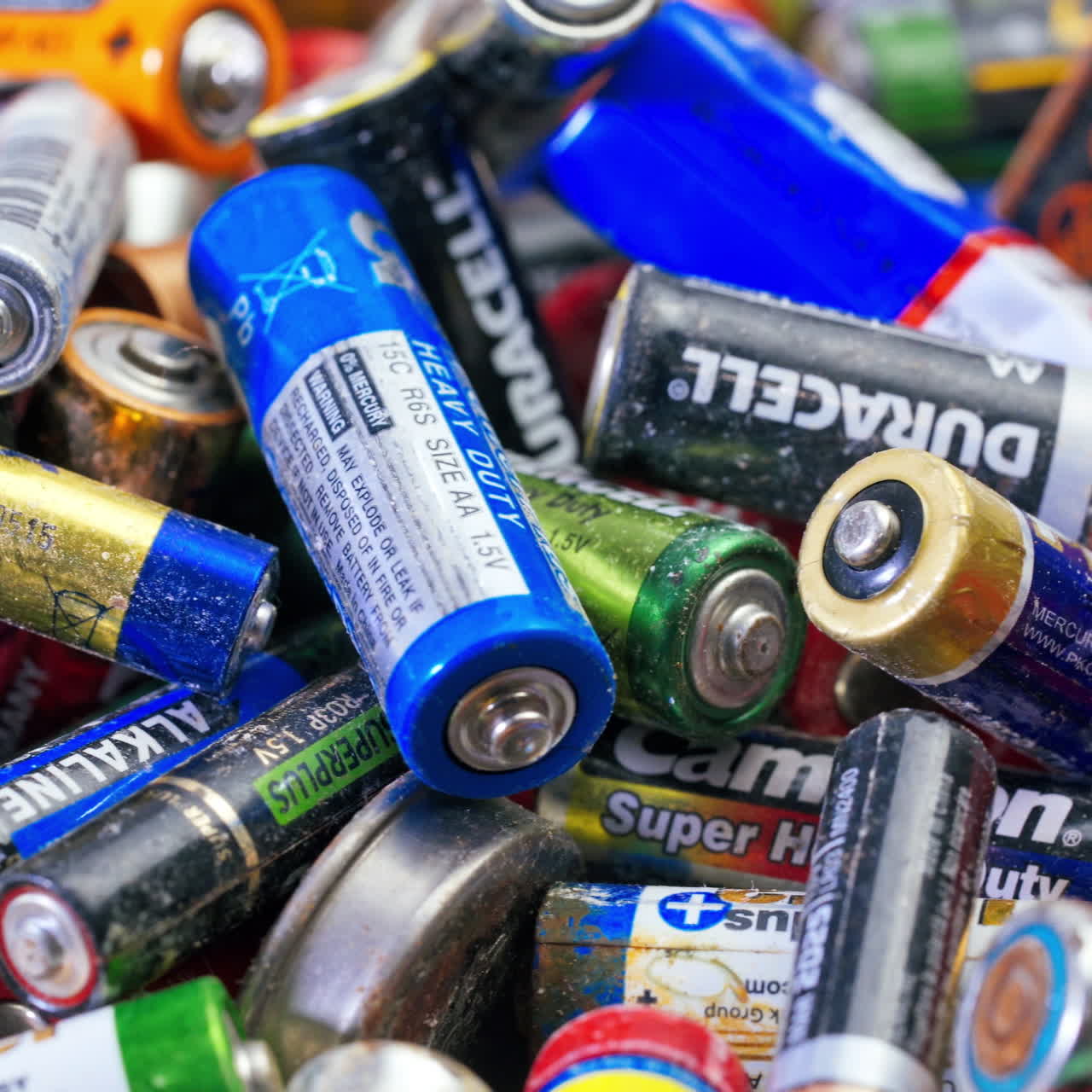 Used batteries from different manufacturers, waste, collection and recycling, high danger for the environment. Batteries background