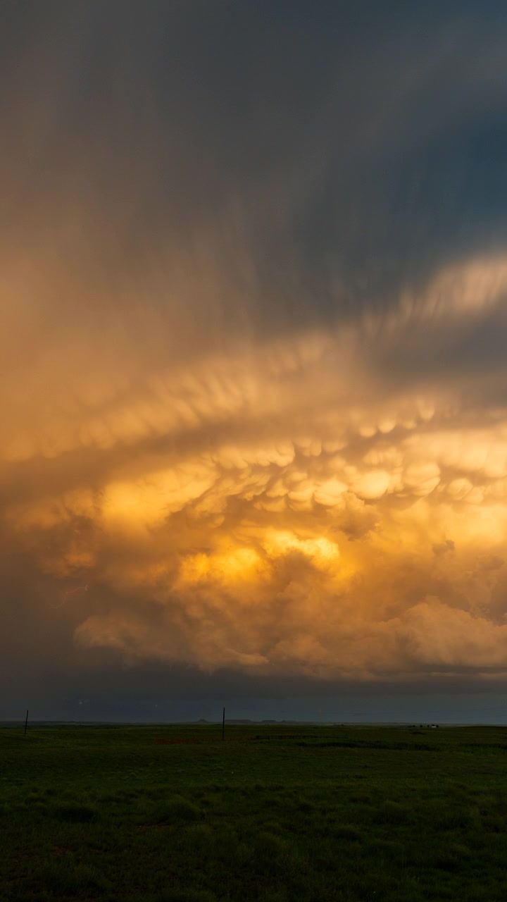 Dark storm clouds glowing at sunset in a dramatic orange weather sky scene