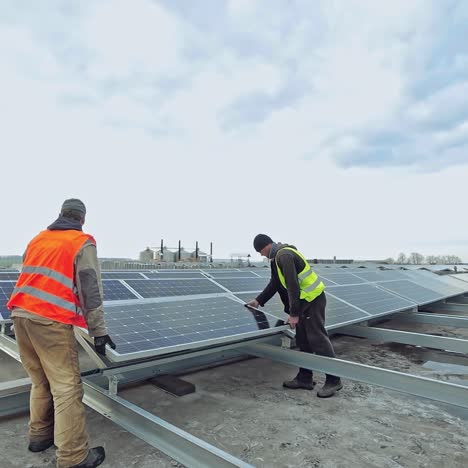 innovative equipment in electricity. workers in protective uniform installing new solar panels on the roof. renewable energy from the sun.
