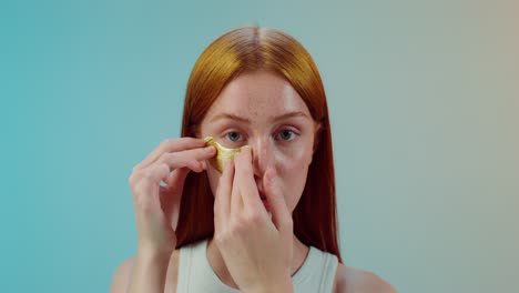 woman applying gold eye mask