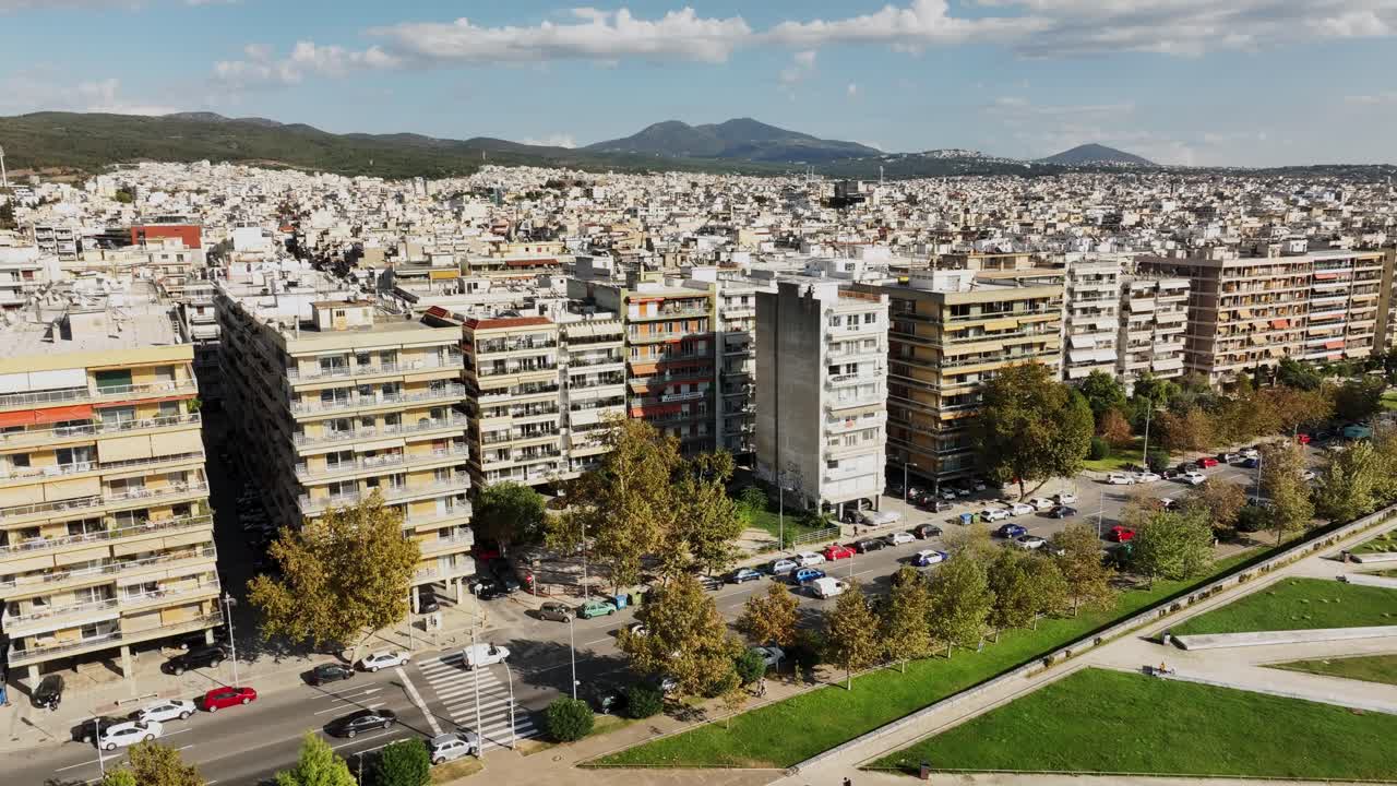 Aerial drone fly city traffic and buildings near Thermaic gulf, Thessaloniki town in Greece during daylight