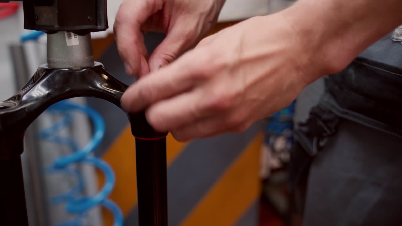 reparador de cultivos desenroscando una horquilla de bicicleta con un destornillador en el taller