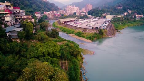 aerial pull back from a bus depot in a river valley