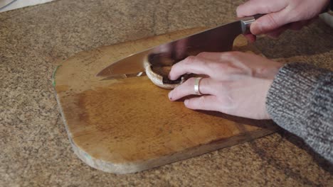 cortar un champiñón en una tabla de cortar de madera