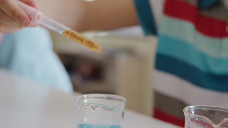 Girl-wearing-glasses-using-pipette-and-beaker