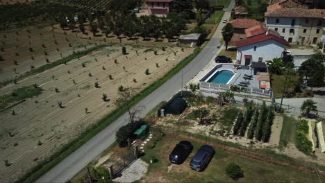 Vista-Aérea-De-Una-Casa-Rural-Y-Un-Camino-En-Un-Paisaje-Típico-Italiano