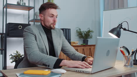 business man winner working browsing typing on laptop at office celebrate big lottery win good news