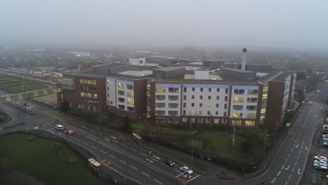 misty foggy hospital building uk town traffic aerial view rising above rooftop