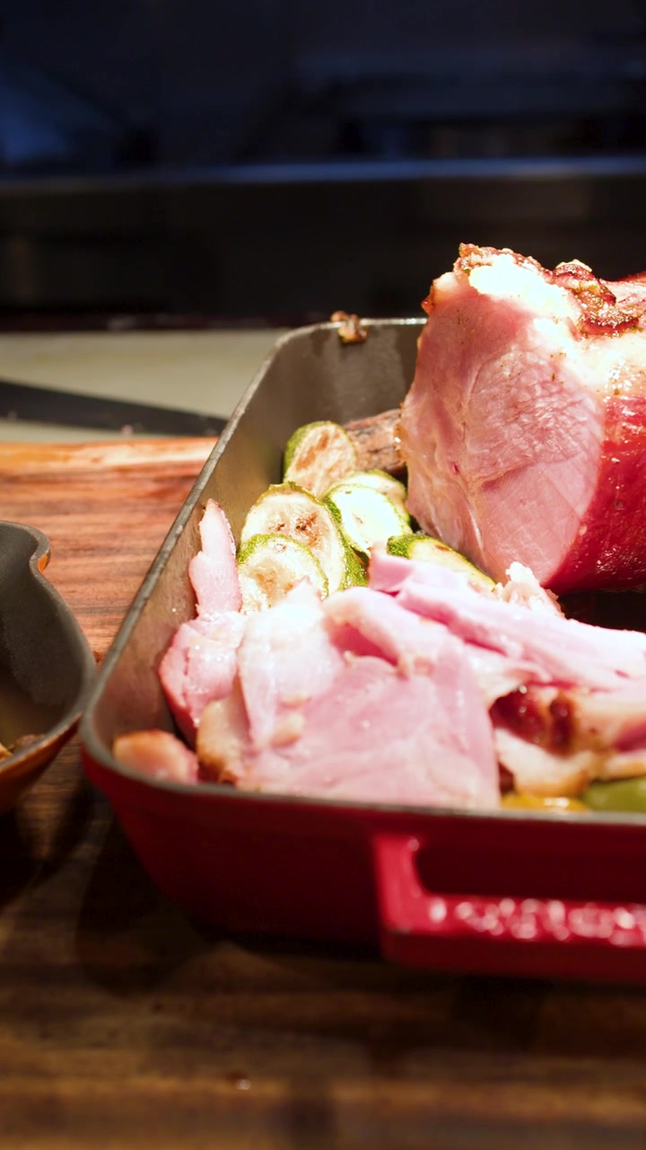 La telecamera panoramica su patate arrosto, verdure grigliate e prosciutto affettato a una stazione buffet di un ristorante.