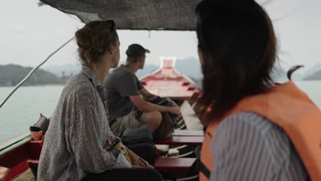People on a longtail boat cruising on a scenic lake