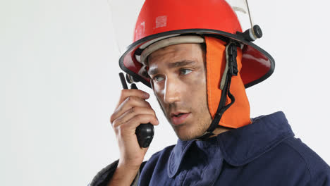 Fireman-talking-on-walkie-talkie-against-white-background-4K-4k