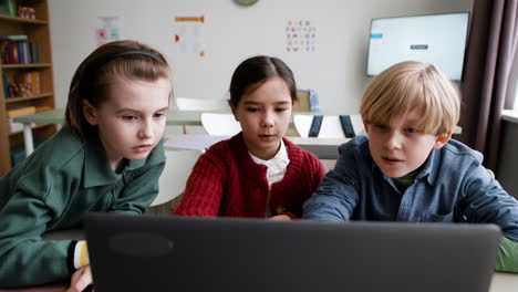 Children Studying Together on a Laptop in a Classroom