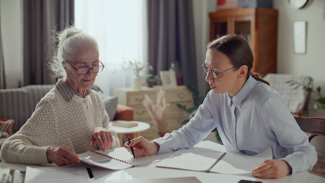 Elderly Woman Consulting with Financial Advisor at Home