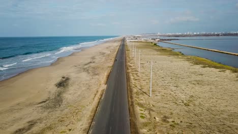 majestic highway road in between ocean and lake water, aerial drone shot