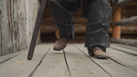 knight walks on wooden bridge leaning on spear heavily