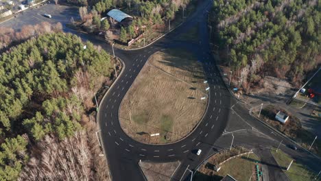 aerial follow shot of several cars drive in a roundabout. cars moving through road junction. shot on mavic 2 pro 4k uhd camera.