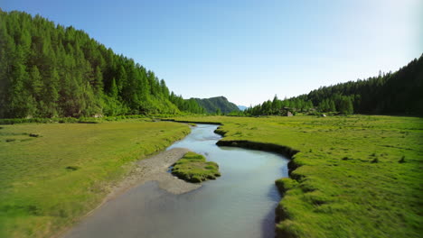 Flying-over-Duino-river-in-Val-Masino-with-forest-in-background-and-sky-for-copy-space