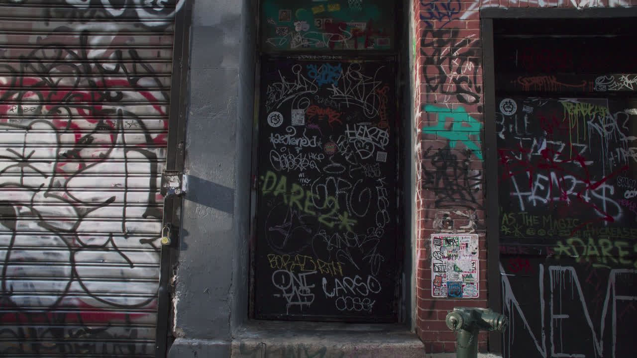 Ripresa a mano di una porta ricoperta di graffiti a New York.