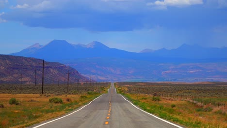 colorado utah border slow zoom in motion highway 90 road moab spanish valley la sal mountain rocky mountains road telluride montrose county summer dry redvale norwood rain thunderstorm clouds sunny