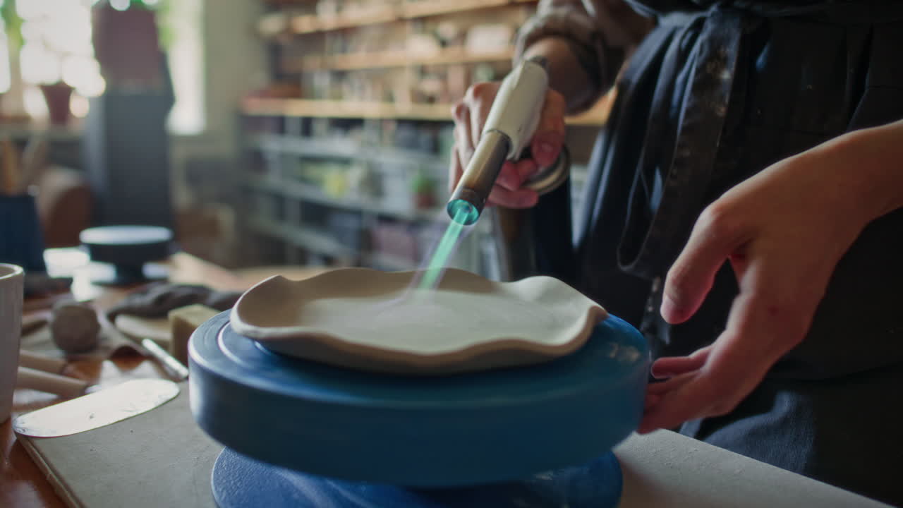 Close-Up of Heating Ceramic Plate with Blowtorch in Pottery Studio