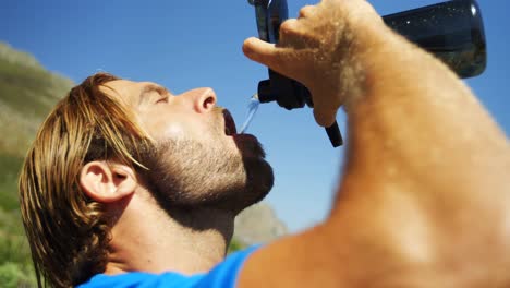 hombre triatleta bebiendo agua en un día soleado