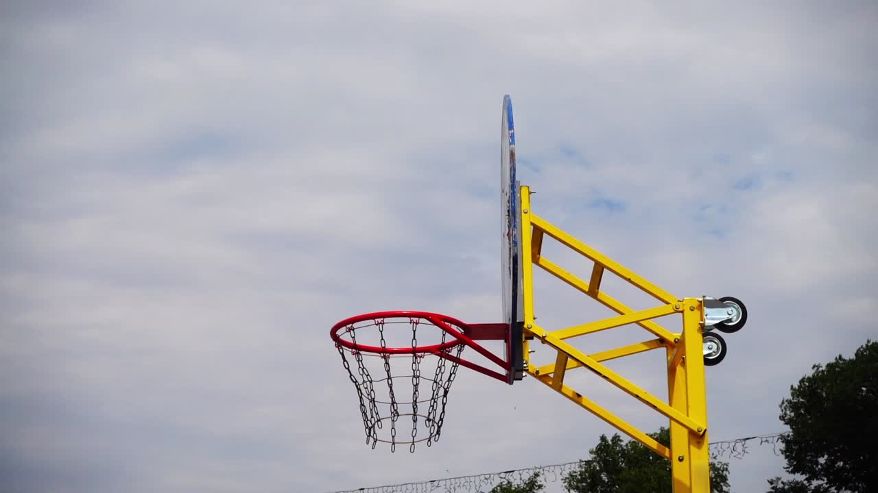 Pallacanestro da strada. La palla vola verso il canestro. Al rallentatore