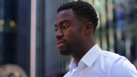 Close-Up-Of-Tired-Young-Businessman-In-Shirt-Sleeves-Rubbing-Eyes-Standing-Outside-Offices-In-The-Financial-District-Of-The-City-Of-London-UK