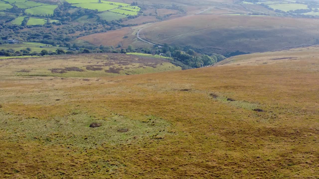 Tilt Up Drone View Over Welsh Countryside with Fields and Forests and a Winding Rural Road 4K