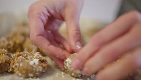 close up dolly of woman's hand pushing down on raw cookie dough