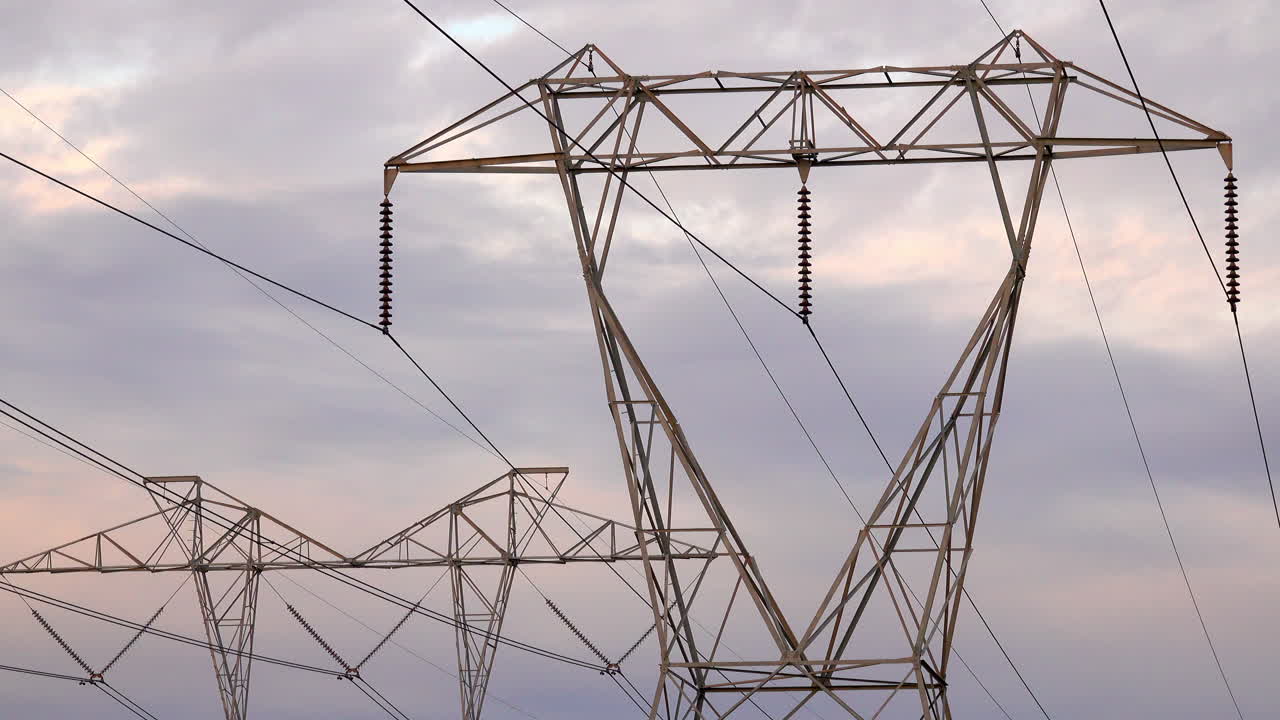 Electrical pylons against grey clouds