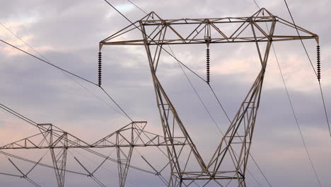 electrical pylons against grey clouds