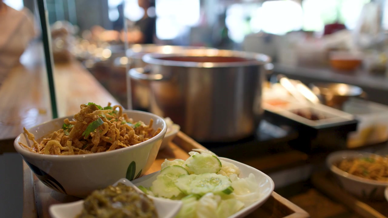 Close-up shot of traditional Thai curry noodles served with crispy egg noodles and fresh vegetables