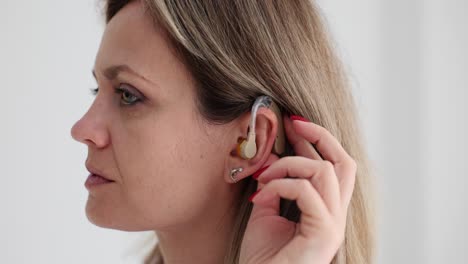 woman adjusting her hearing aid