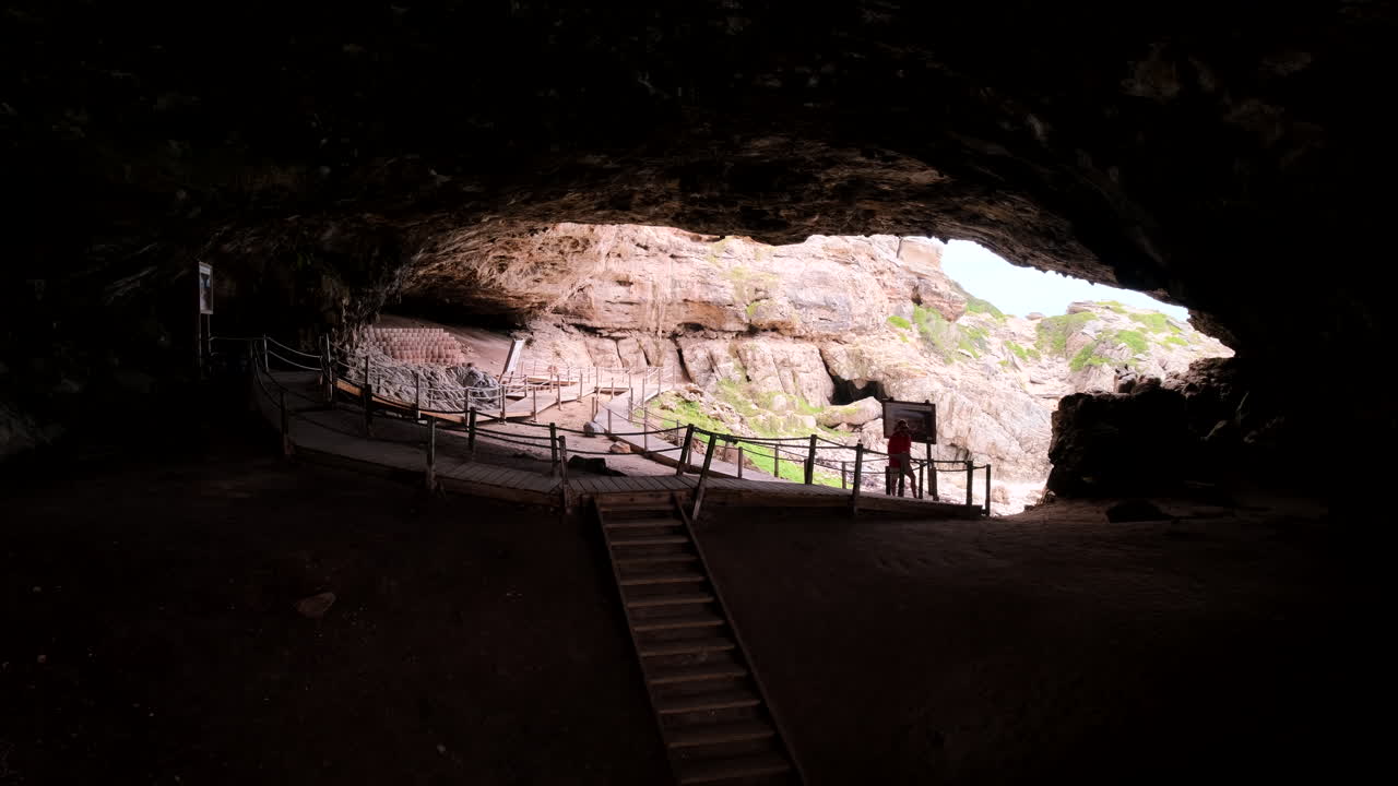 Male traveler explores massive main chamber of historic Klipgat Cave, De Kelders