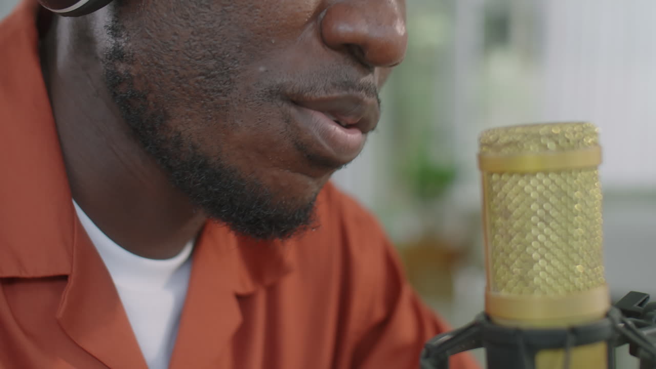 Uomo afroamericano che parla al microfono e registra un podcast